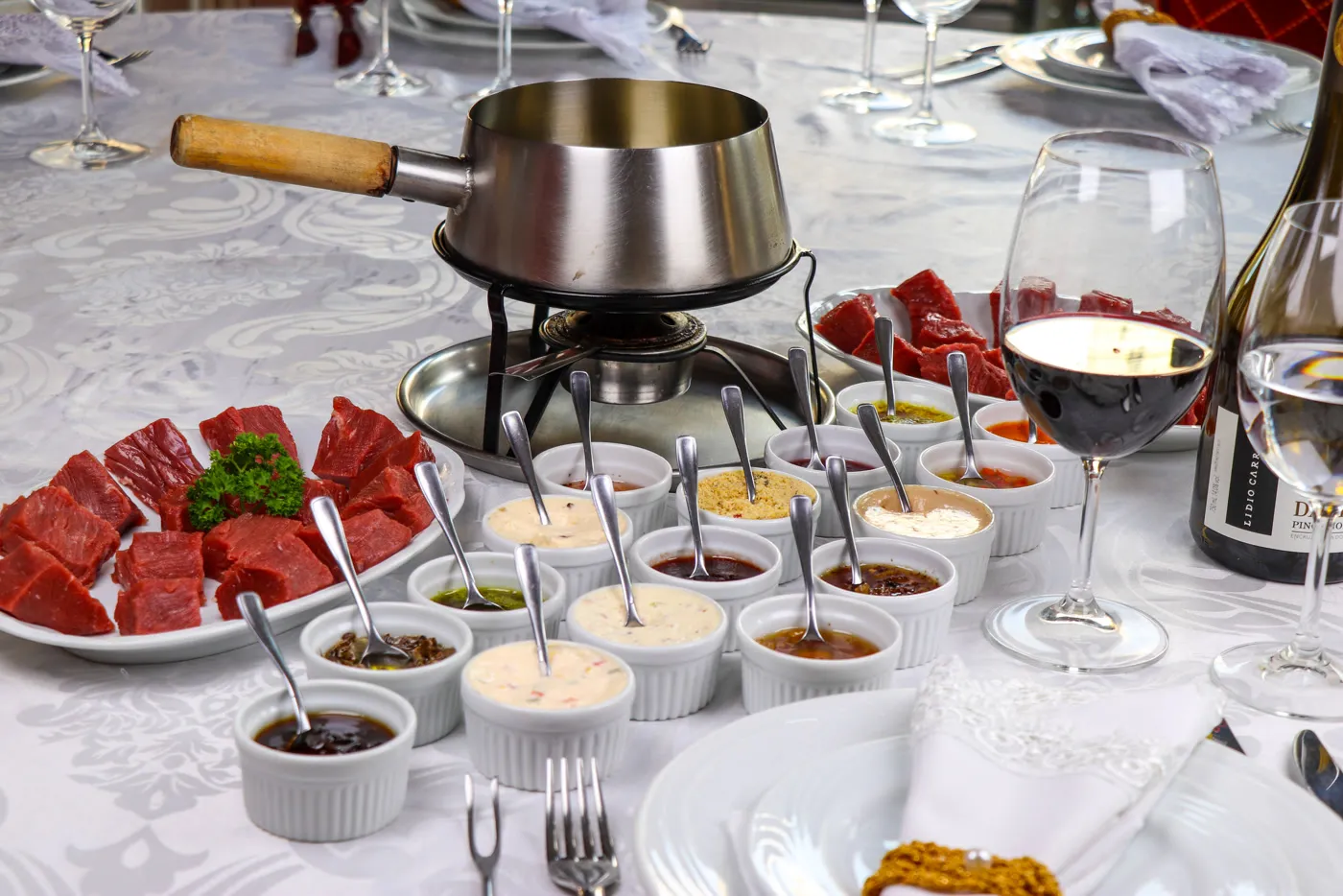Fondue sequence at Le Chalet: table set with meats, sauces and wine